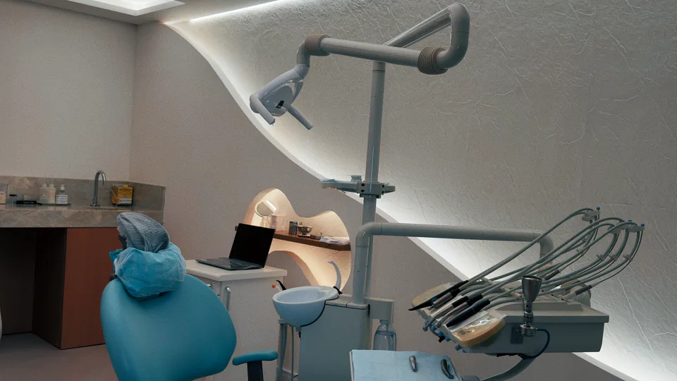Consultório com cadeira odontológica azul e parede iluminada em curva
