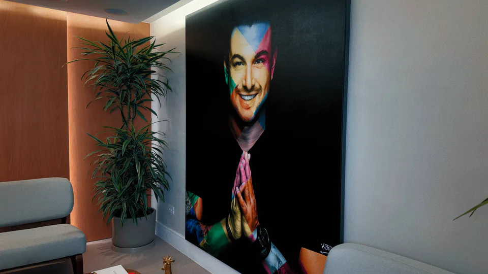 Sala de espera com planta e retrato artístico de Rafa Puglisi