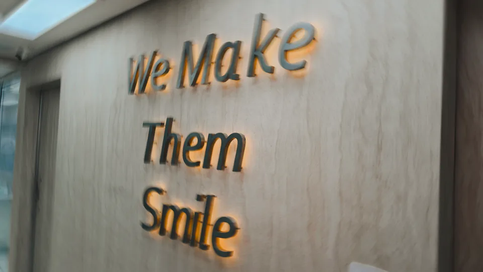 Frase We Make Them Smile aplicada sobre parede de pedra