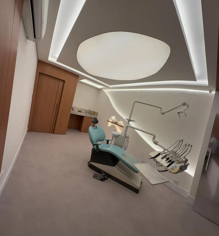Consultório odontológico completo com cadeira azul e iluminação no teto