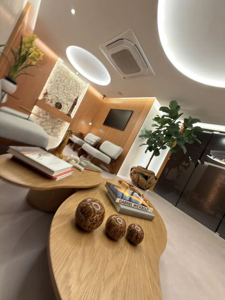 Detalhe vertical de mesa de madeira, objetos e poltronas da sala de espera