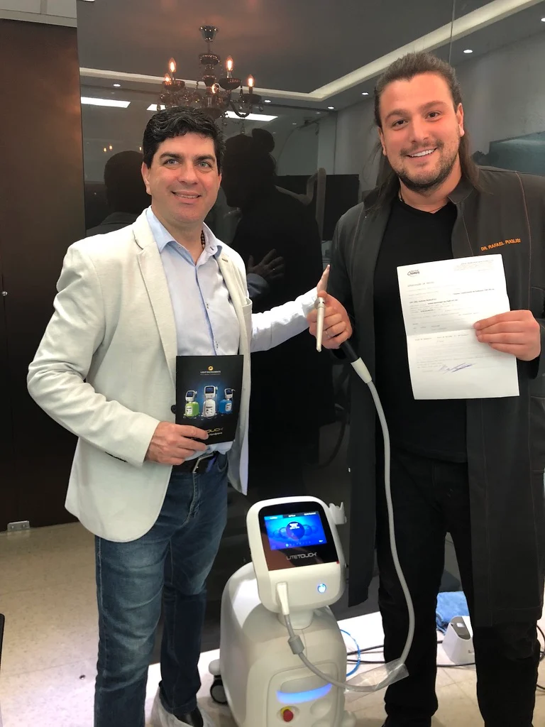 Tony Carreon e Rafa Puglisi ao lado de um equipamento LiteTouch