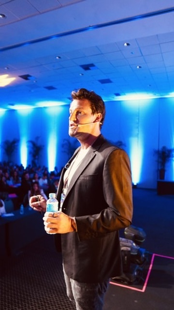 Rafa Puglisi falando ao público em um evento de odontologia.