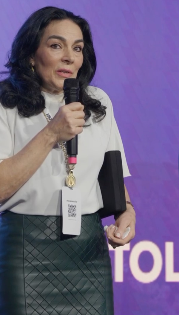 Silvana Puglisi falando ao microfone durante um evento de odontologia.